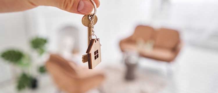 homme tenant une clé et un porte clé de maison dans sa nouvelle propriété